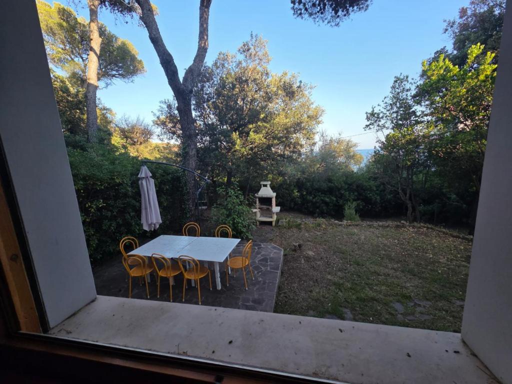 Blick aus einem Fenster auf einen Tisch und Stühle in der Unterkunft Beachside Villa in Quercianella