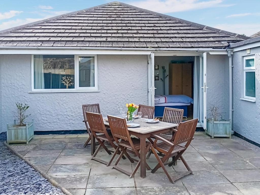 a table and chairs in front of a house at Dihangfa Wylau in Tywyn