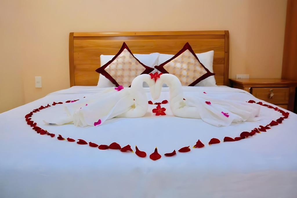 two white wedding dresses are laid out on a bed at Sông Kinh Hotel - Hồ Tràm in Xóm Trương Quít