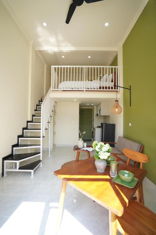 a living room with a table and a staircase at Nagomi Studio Nyanyi in Cemagi