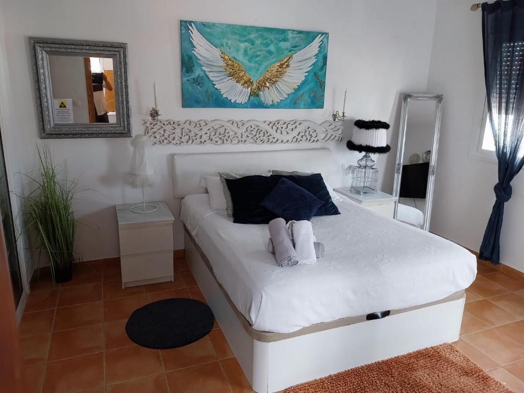 a white bed in a room with a mirror at Circus-Goretti House in Mairena del Aljarafe
