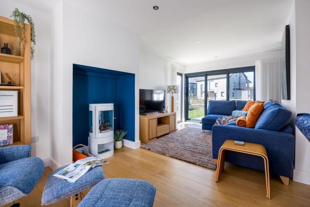 a living room with a blue couch and a tv at Cosy Cottage in Dorchester