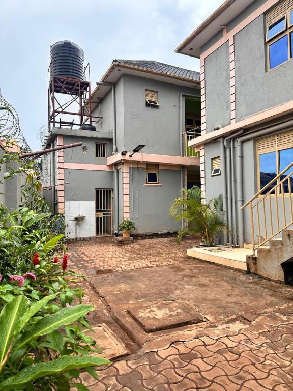 a house with a stone driveway in front of it at Zone hotel and guest house in Bugembe