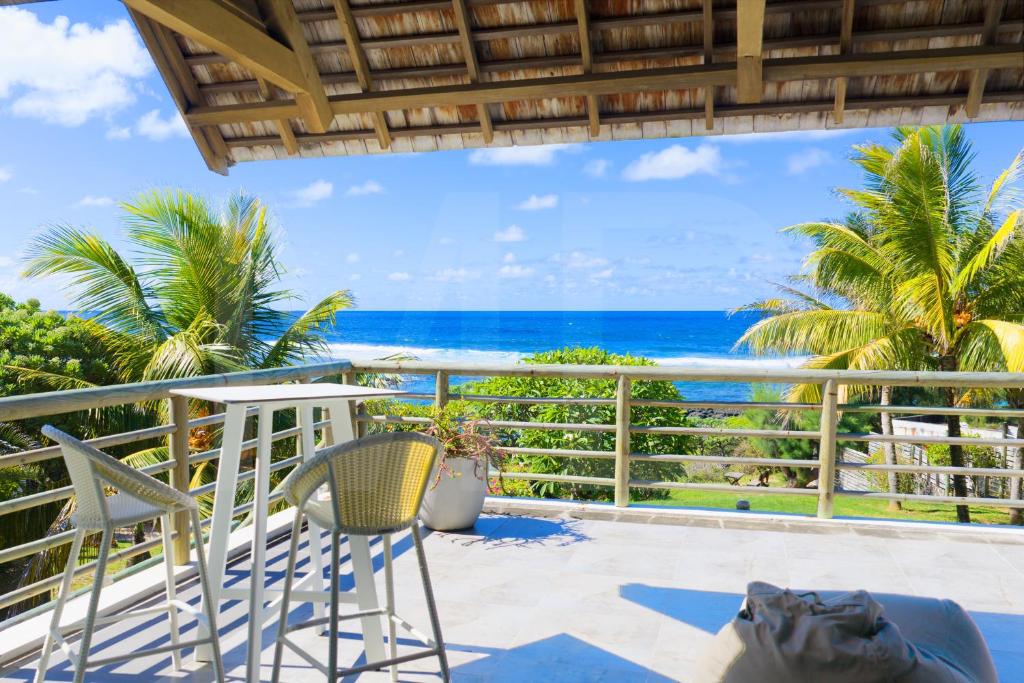 a balcony with chairs and a view of the ocean at Peter's Beach House in Poste Lafayette
