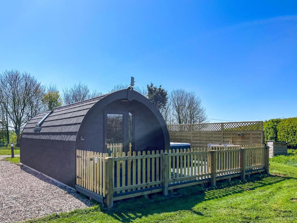 a small black dome house with a wooden fence at Oak - Uk51863 in Reighton