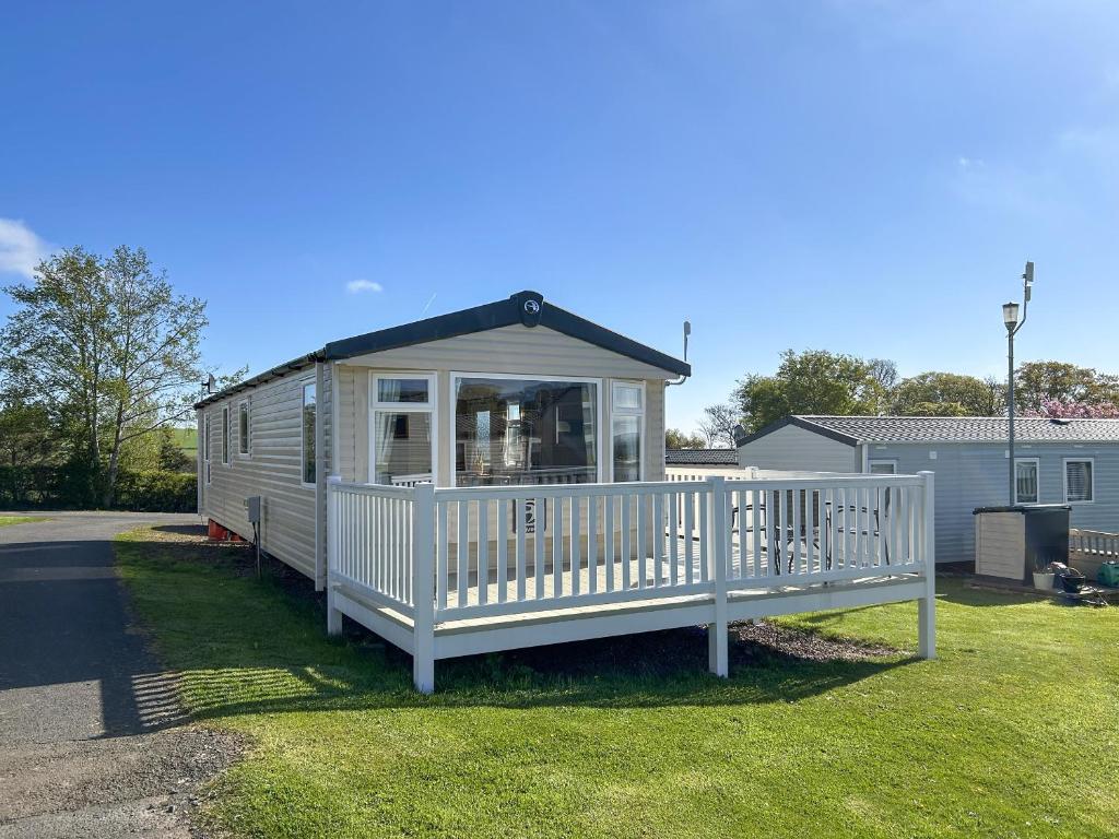 a tiny house with a porch on the grass at Hamilton Unit 145 in Eyemouth