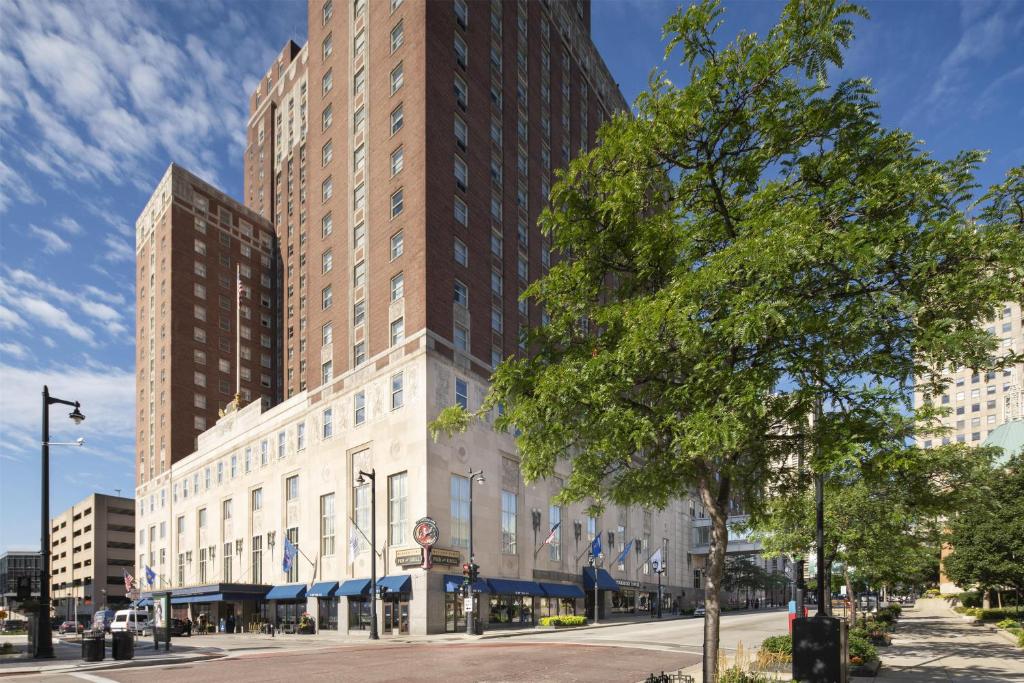 a tall building on a city street with a tree at Hilton Milwaukee in Milwaukee