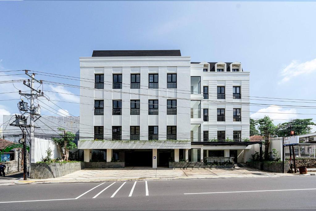 a white building on the corner of a street at Rucio Kostel Semarang in Jatingaleh