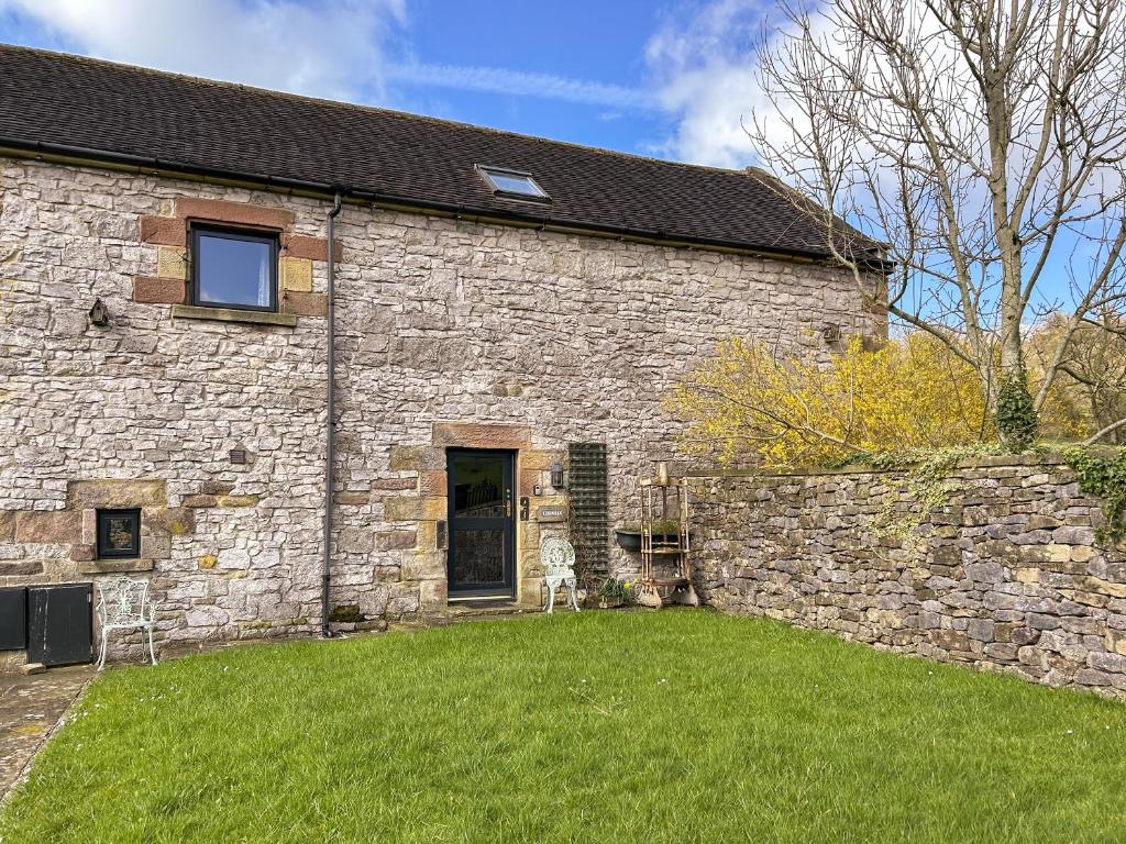 a stone building with a yard in front of it at Ostlers End in Hartington