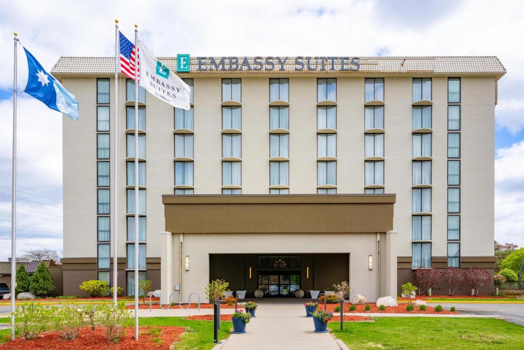 a hotel with two flags in front of it at Embassy Suites by Hilton Minneapolis Bloomington Edina in Bloomington