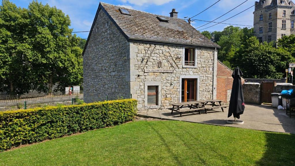 a stone building with a picnic table and a bench at La Maison de Durbuy in Durbuy
