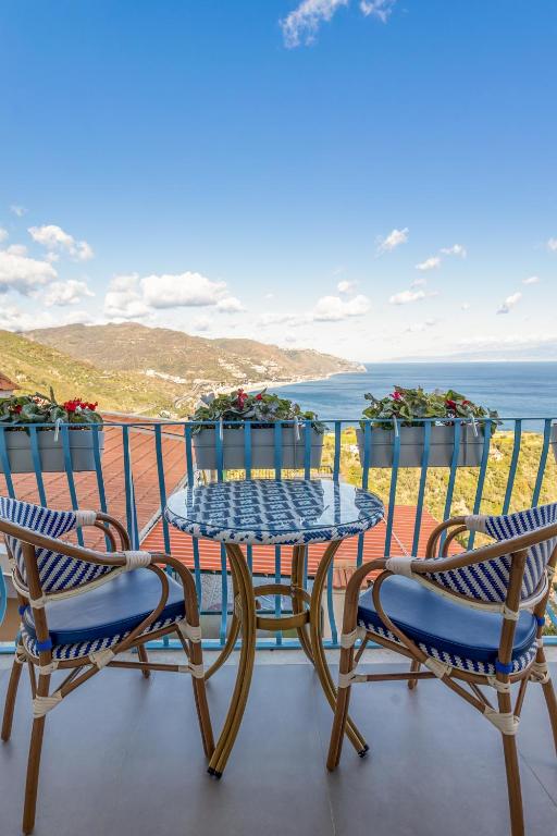 a table and chairs on a balcony with the ocean at Athena Charming Rooms in Taormina
