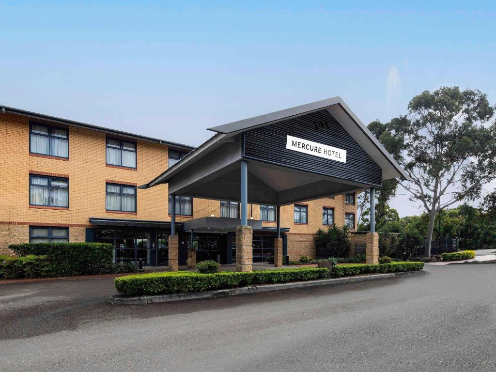 a hotel with a sign on top of a building at Mercure Sydney Blacktown in Blacktown