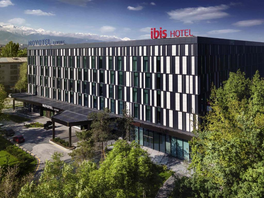 an office building with a bus hotel sign on top at ibis Almaty Jetisu in Almaty