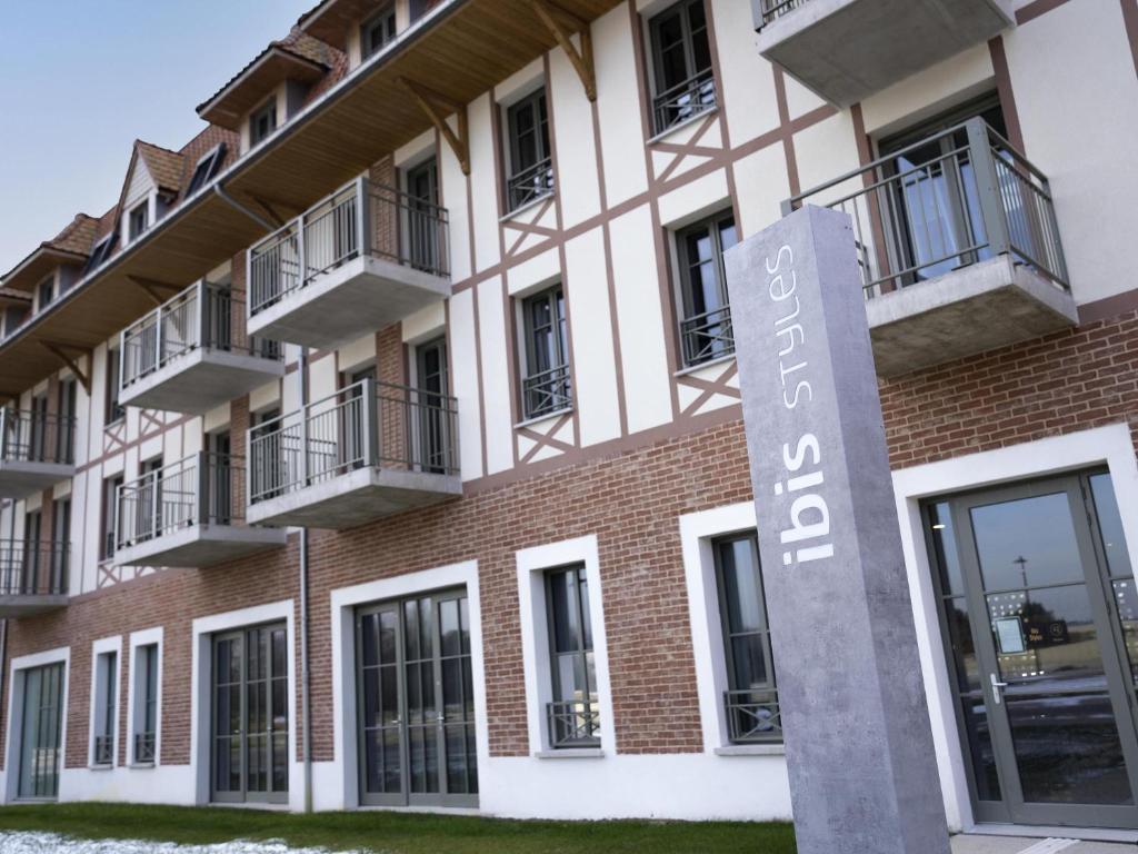 an apartment building with a sign in front of it at Ibis Styles Le Touquet in Le Touquet-Paris-Plage