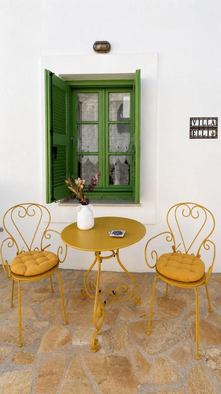 a table and two chairs in a room with a green window at Villa Elli in Halki