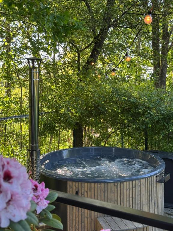 a hot tub on a deck with flowers at Silver Bungalow in Săcele