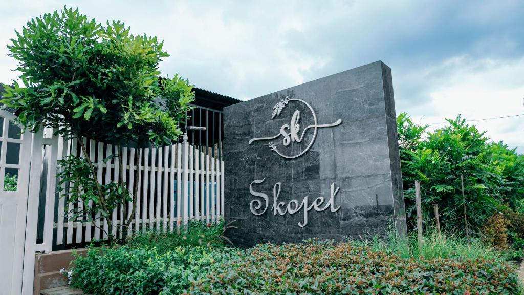 a sign for a shop in front of a fence at Skojet Boutique Hotel in Ruhengeri