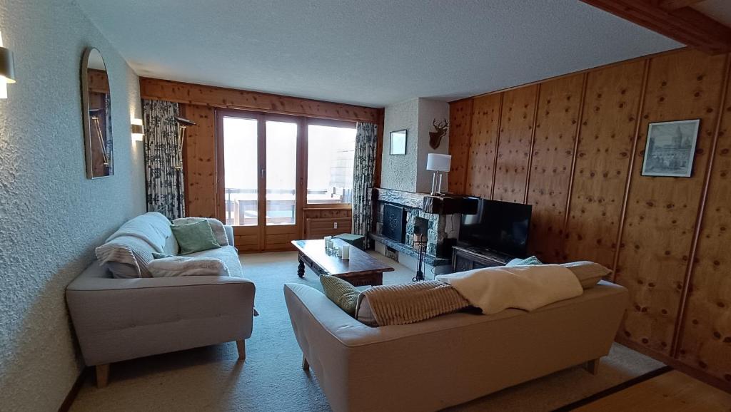a living room with a couch and a tv at Majestic 424 in Bagnes