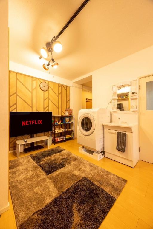 a living room with a washing machine and a rug at New コスパ重視セール開催中!久留米駅徒歩5分コンビニ1分!ファミリー 友人快適!キッズエリア大好評 in Kurume