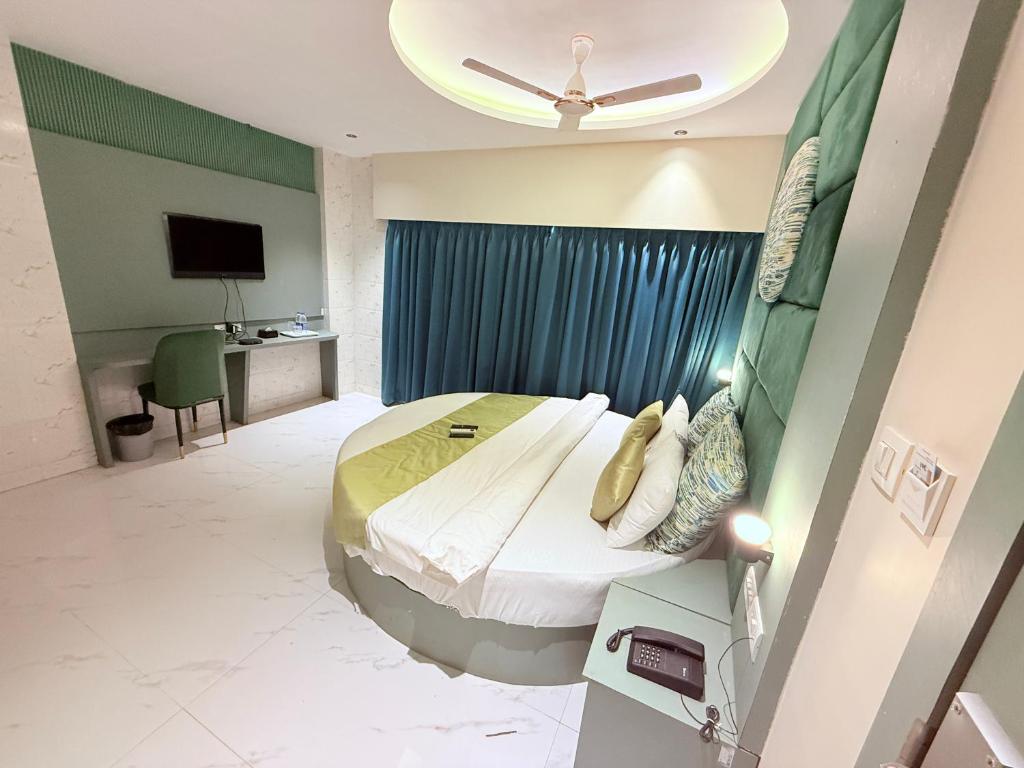 a hotel room with a bed and a television at Hotel Adkar Residency Borivali West in Mumbai
