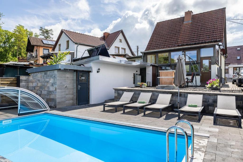 a swimming pool in the backyard of a house at Ferienhaus Eisfelder Blick in Eisfeld