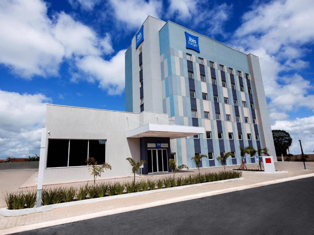 a large white building with a blue sign on it at IBIS BUDGET CAPAO Bonito in Capão Bonito