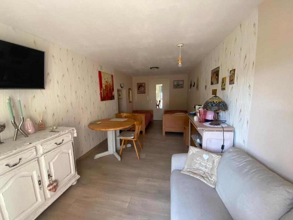 a living room with a couch and a table at Le temps d'une pause bed and breakfast in Servance
