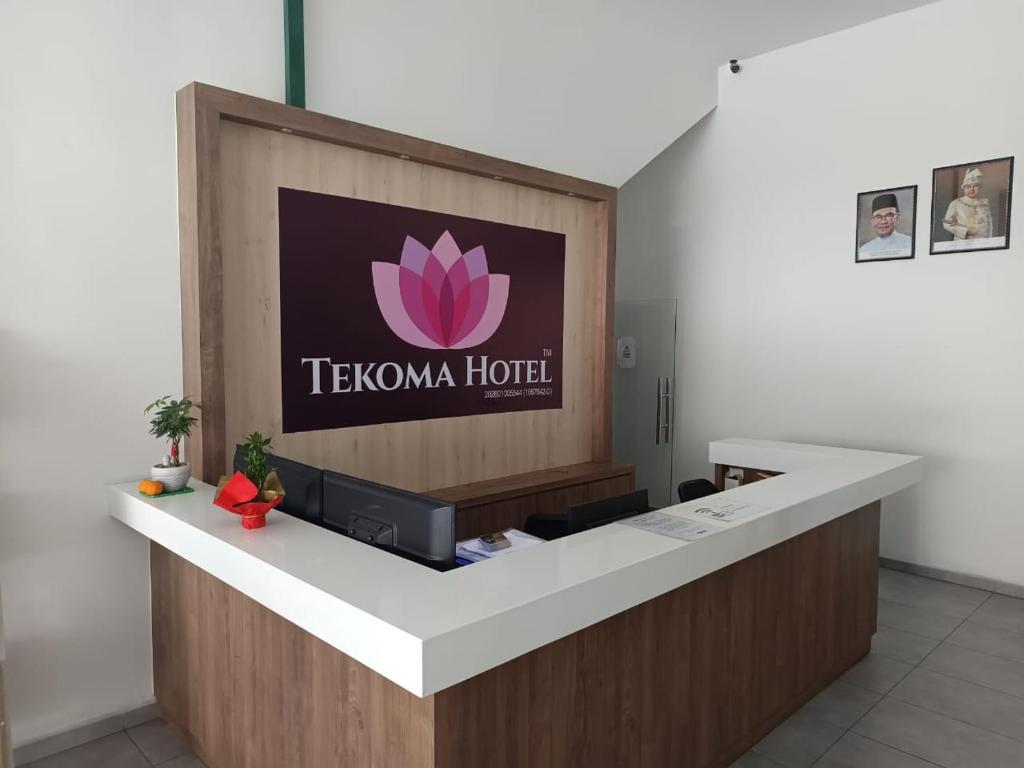 a reception desk with a tlvanna hotel sign on the wall at Tekoma Hotel Ipoh - Dandelion Inn in Simpang Pulai