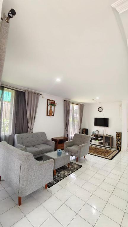 a living room with two couches and a tv at Villa Dalia Puncak N5-10 in Cikundul
