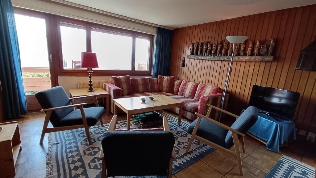 a living room with a couch and chairs and a table at Panorama 14 in Bagnes
