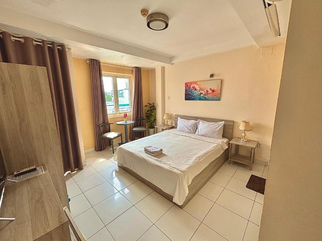 a bedroom with a white bed and a window at Liva in Ho Chi Minh City