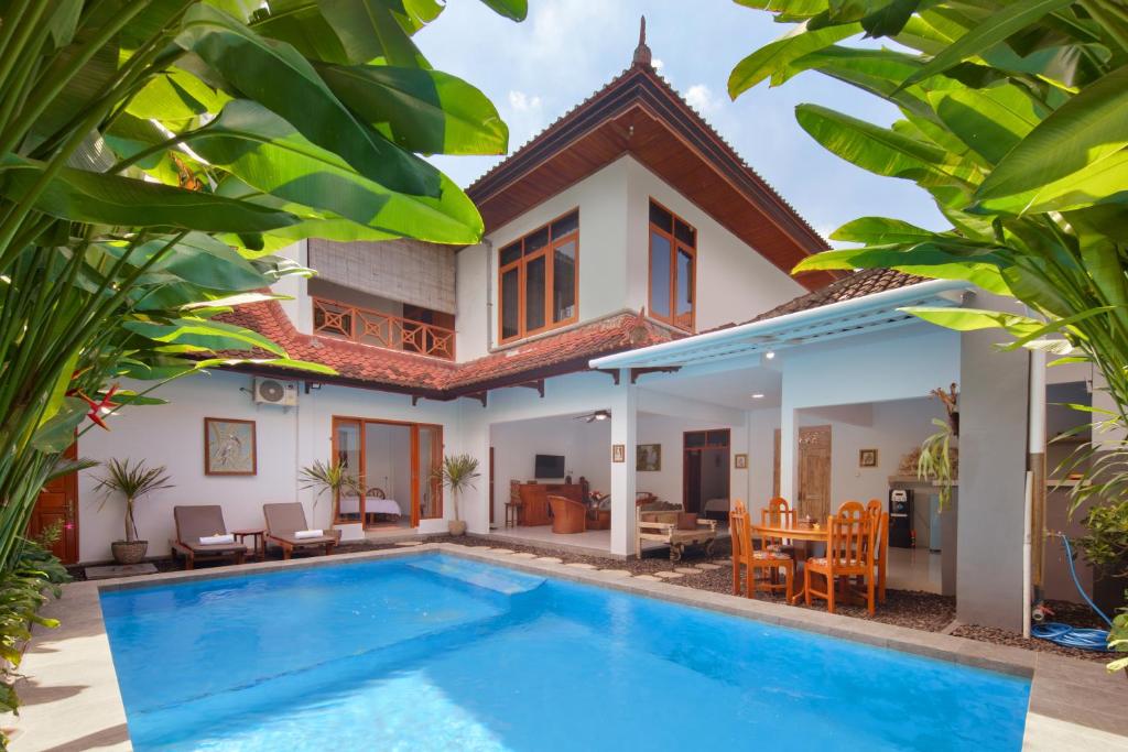 a villa with a swimming pool in front of a house at Hildiman Villa Kuta - Two Bedroom Private pool in Kuta