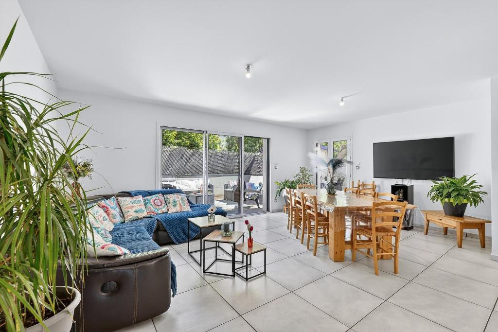 a living room with a blue couch and a dining room at Location Vacances Chorges in Chorges