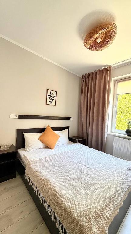 a bedroom with a bed with an orange pillow at Hotel Dolynskiy in Lviv