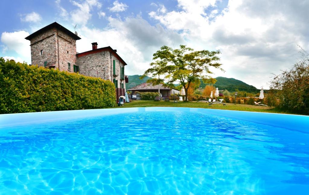 an outdoor swimming pool in front of a castle at Antico Casale di Bobbio B&B in Bobbio