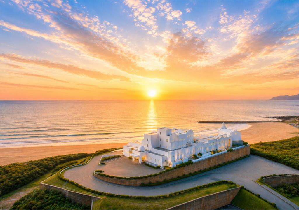 an aerial view of a hotel on the beach at sunset at Hotel Greges in Munakata