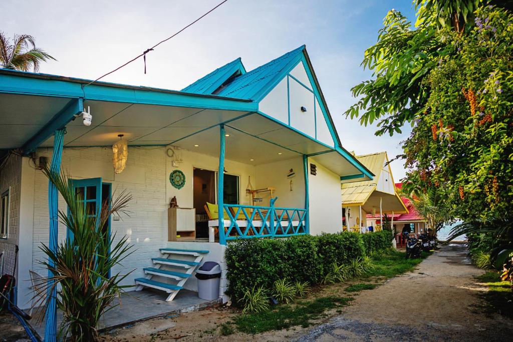 a house with a blue roof and a blue bench at Dream Villa Beachside Sunset in Ban Bang Po