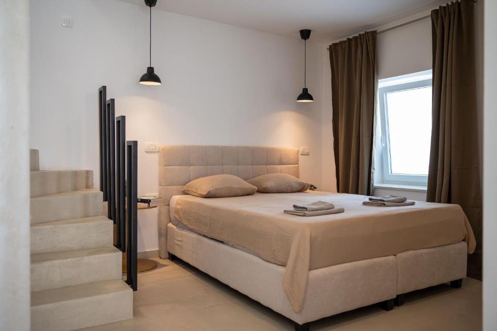 a bedroom with a large bed and a staircase at Fonte Perila House in Funtana