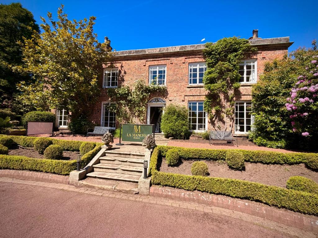 a brick building with a sign in front of it at La Mancha Hall Stately Home in Halsall