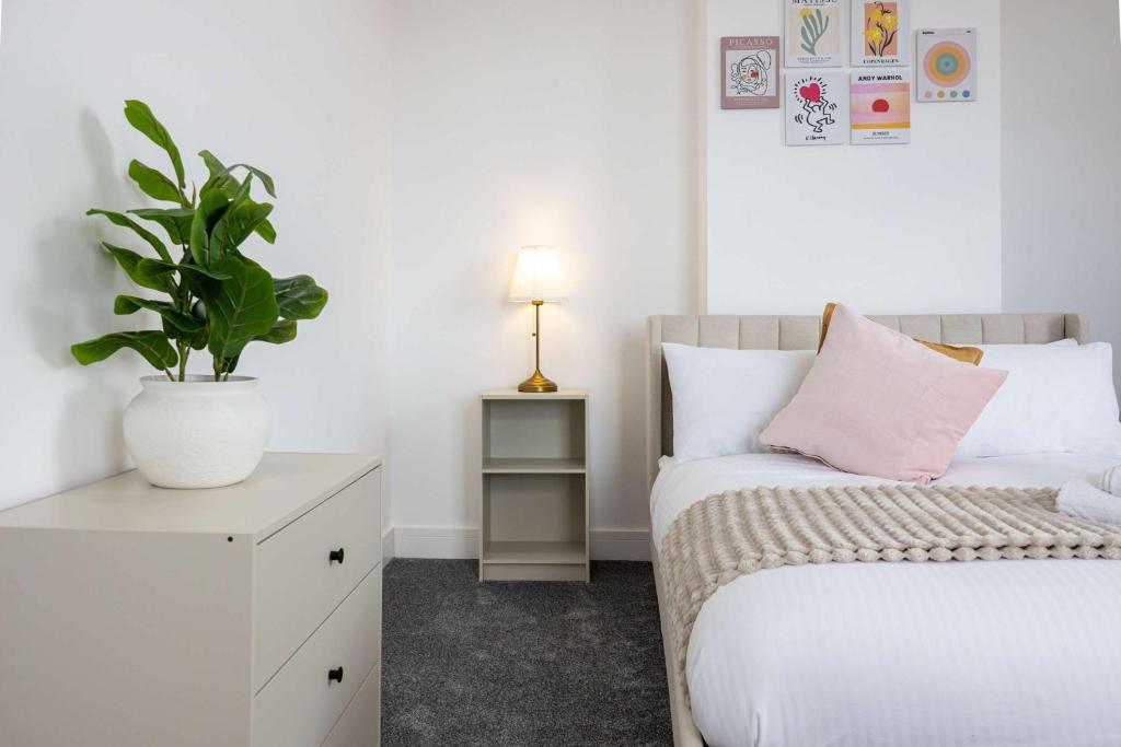 a bedroom with a bed and a potted plant at The Loft Apartment in Elland