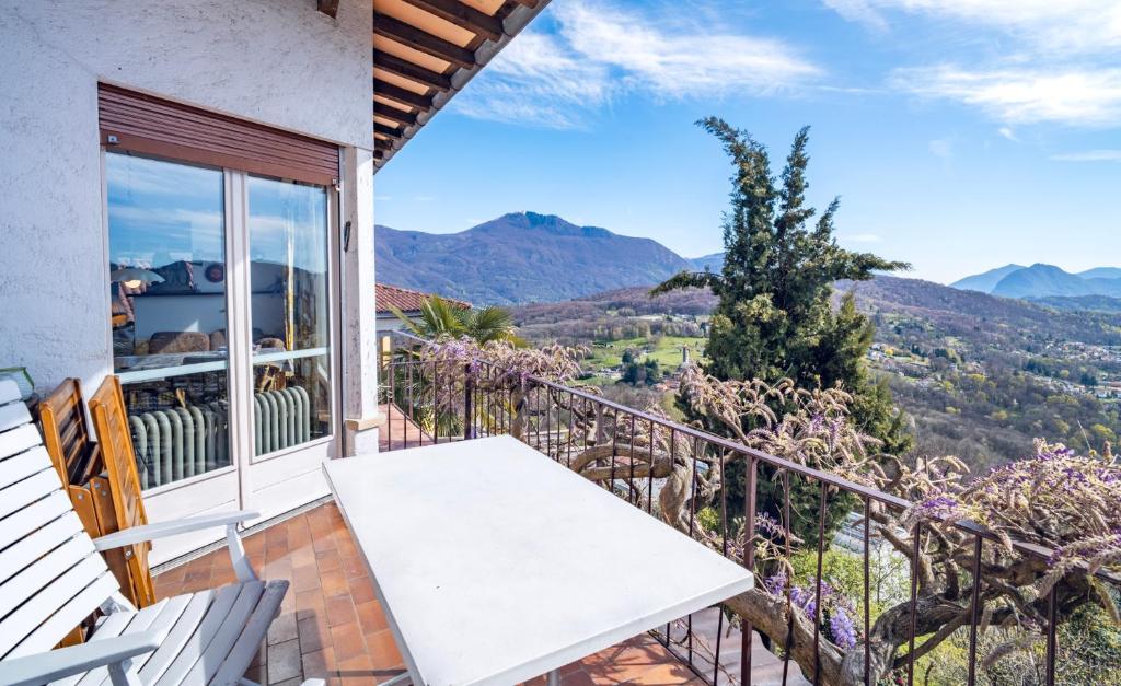 a balcony with a bench and a view of mountains at Lugano Hills View & Parking in Bigorio