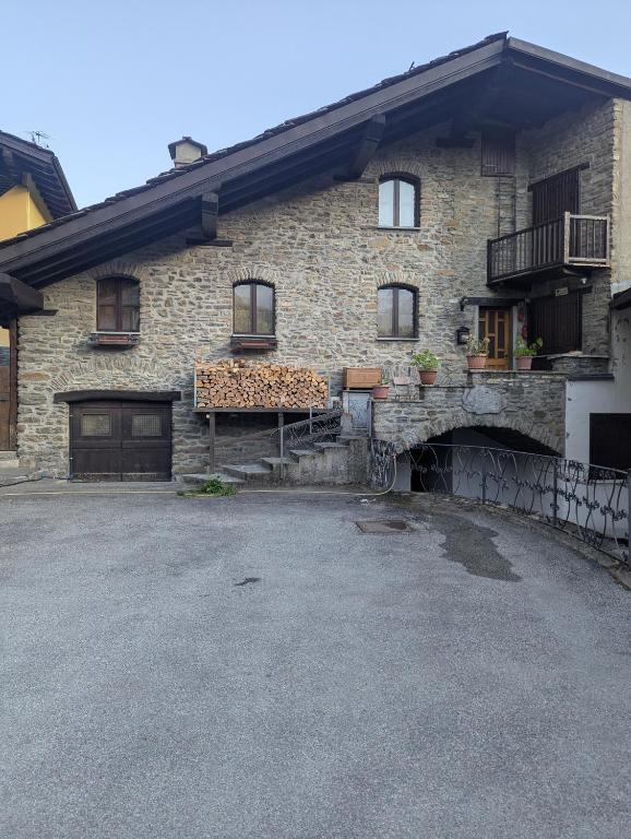 a stone house with a garage and a driveway at La meison de Rita in Pré-Saint-Didier