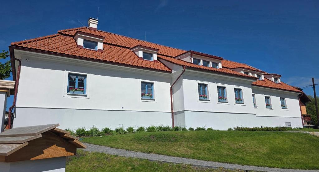 a large white house with a red roof at Penzión Jánsky kaštieľ Bohumírovský in Liptovský Ján