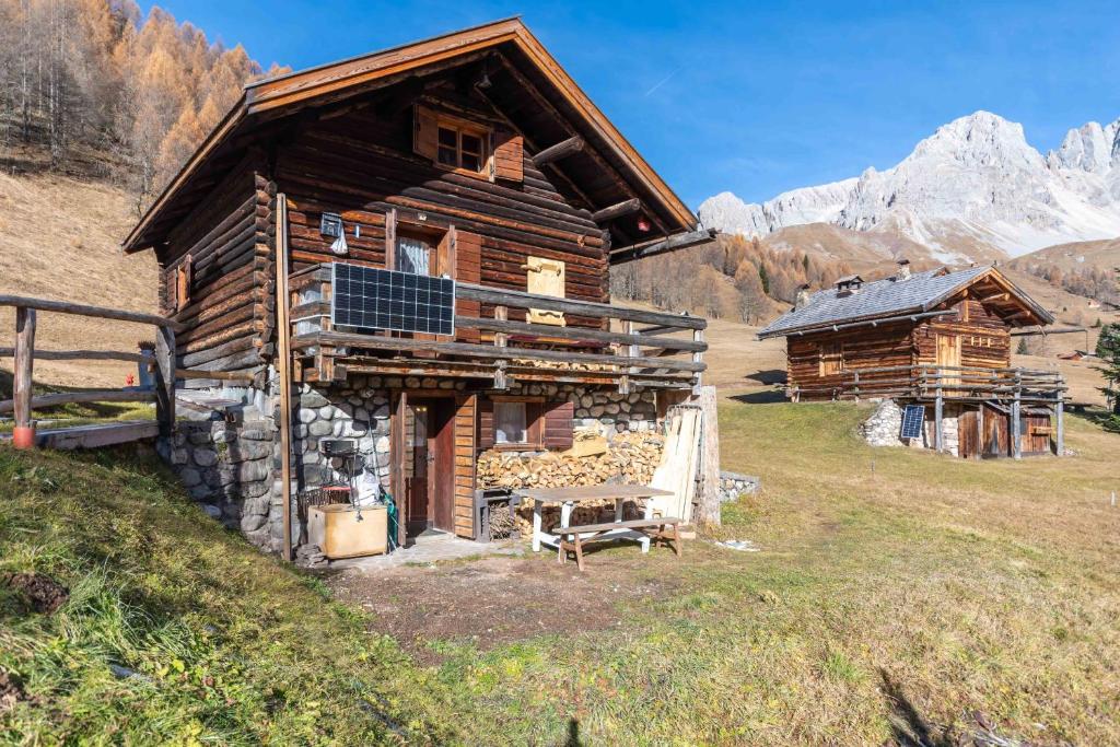 a log cabin with a bench in front of it at Baita Lodge Valfreda in Falcade