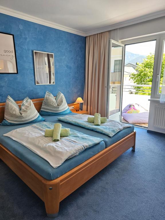 a bedroom with two beds with blue walls at Pension Schachner in Schladming