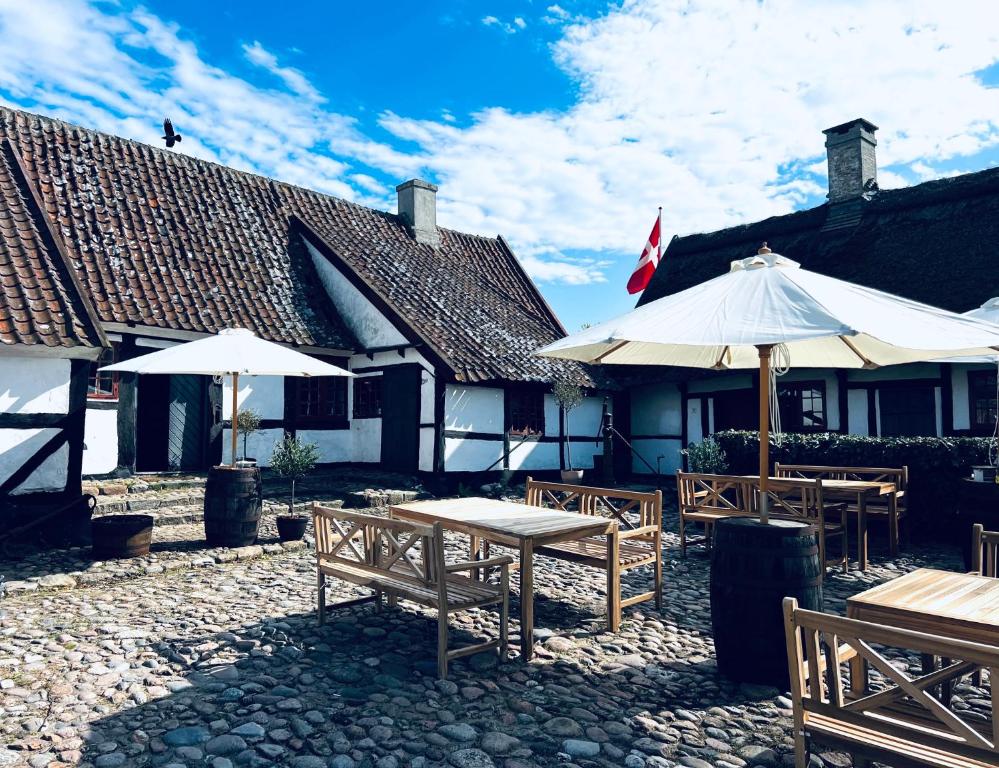 a group of tables and umbrellas in front of a building at Lodsoldermandsgården in Rørvig
