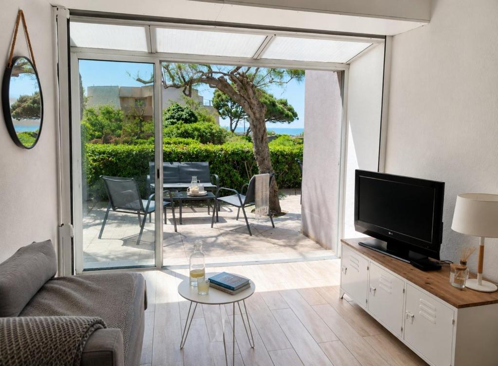 a living room with a couch and a television at Le Cosy - T4 avec terrasse privée, Face à la mer avec parking et wifi in Sète