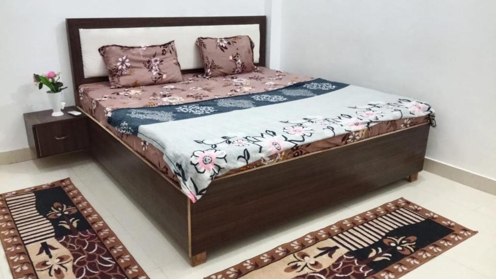 a bed in a room with two rugs at Pandeyji stay in Ayodhya