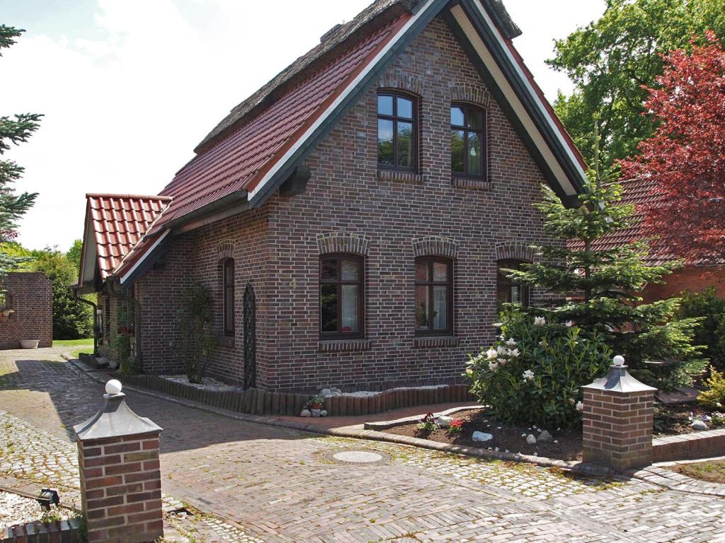a brick house with a gambrel roof at Ferienhaus am Badesee 4 in Aurich